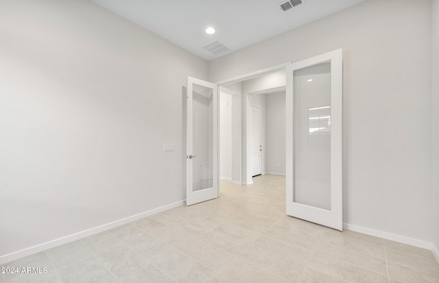 tiled empty room with french doors