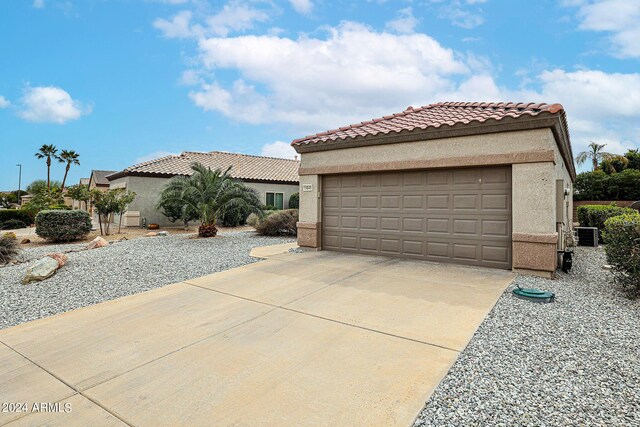 mediterranean / spanish-style home with a garage and an outbuilding