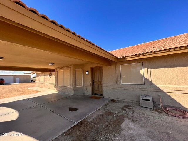 view of exterior entry with a patio area