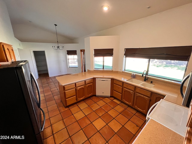 kitchen with hanging light fixtures, white dishwasher, vaulted ceiling, stainless steel refrigerator, and sink