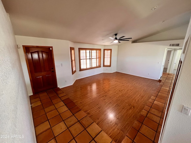 unfurnished living room featuring ceiling fan, lofted ceiling, and dark hardwood / wood-style floors