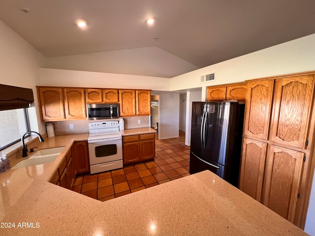 kitchen featuring sink, fridge, dark tile patterned floors, lofted ceiling, and white range with electric stovetop