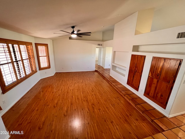 unfurnished living room with lofted ceiling, hardwood / wood-style flooring, and ceiling fan