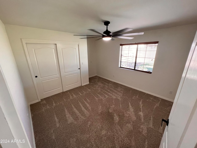 unfurnished bedroom featuring a closet, ceiling fan, and dark colored carpet