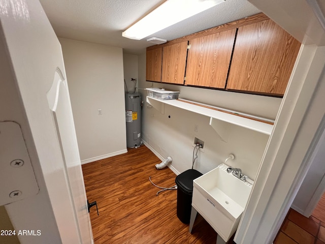 laundry room with electric water heater, washer hookup, a textured ceiling, light wood-type flooring, and sink