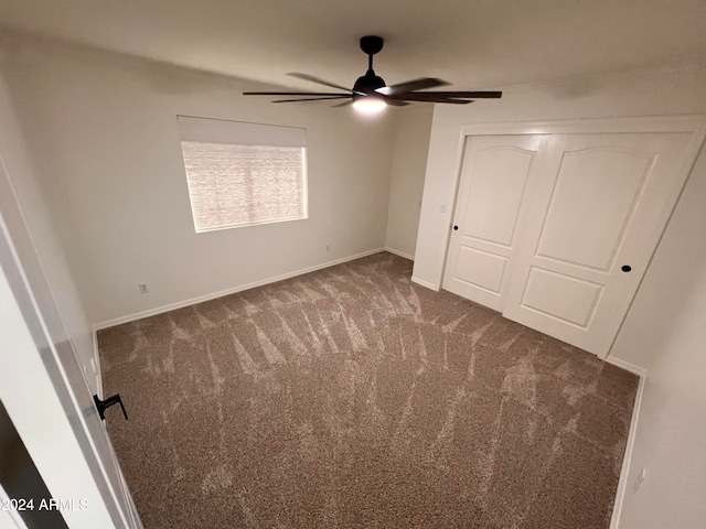 unfurnished bedroom with a closet, carpet flooring, and ceiling fan