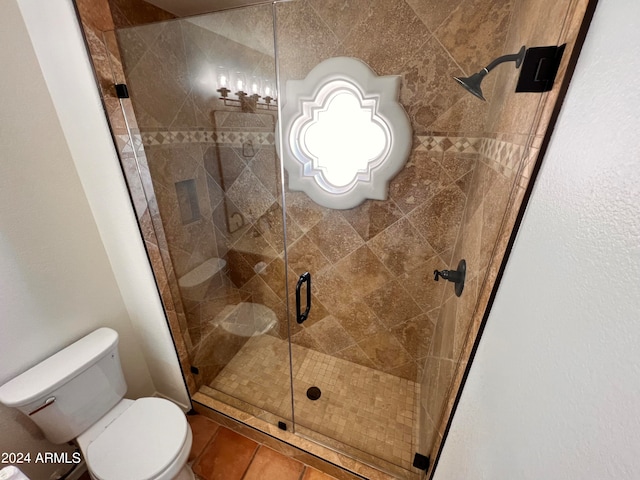 bathroom featuring a shower with door, toilet, and tile patterned floors