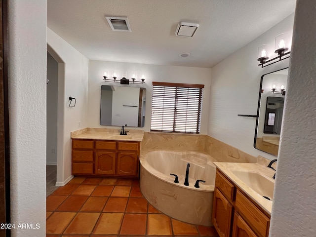 bathroom featuring vanity, a bathtub, a textured ceiling, and tile patterned flooring