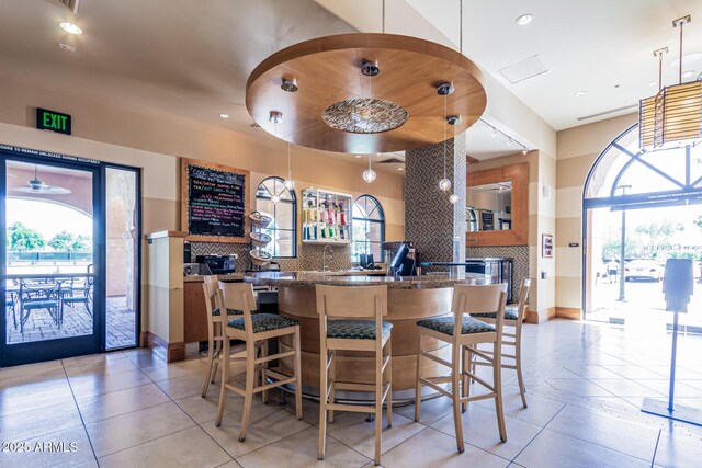 16747 W Berkeley Rd, Goodyear, AZ 85395 - bar with light tile patterned floors, backsplash, plenty of natural light, and recessed lighting