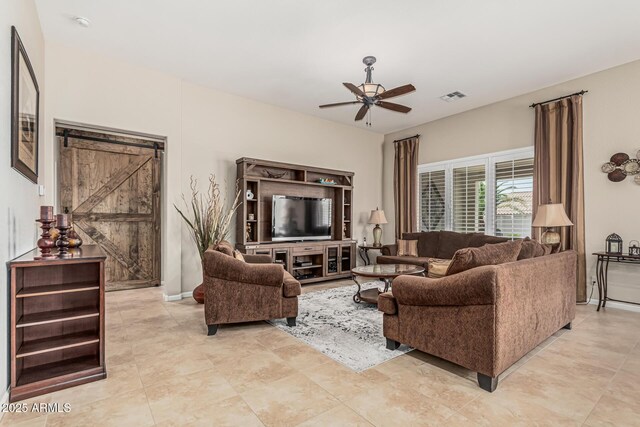 16747 W Berkeley Rd, Goodyear, AZ 85395 - living area featuring a ceiling fan, a barn door, light tile patterned floors, and baseboards