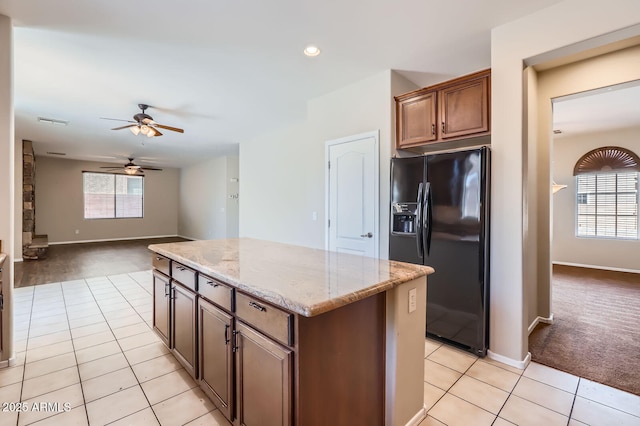 1710 S Parkcrest St, Gilbert, AZ 85295 - kitchen featuring black fridge with ice dispenser, light carpet, ceiling fan, light tile patterned flooring, and light stone countertops