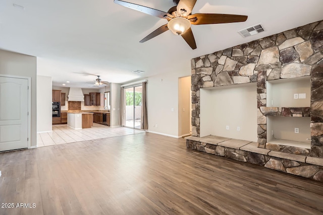 1710 S Parkcrest St, Gilbert, AZ 85295 - unfurnished living room with ceiling fan, light wood-style flooring, and baseboards