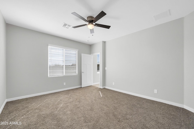 carpeted empty room featuring visible vents, ceiling fan, and baseboards