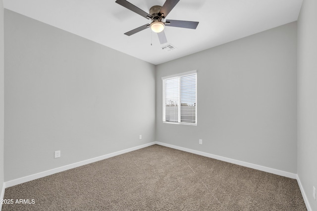 empty room with visible vents, carpet floors, baseboards, and a ceiling fan