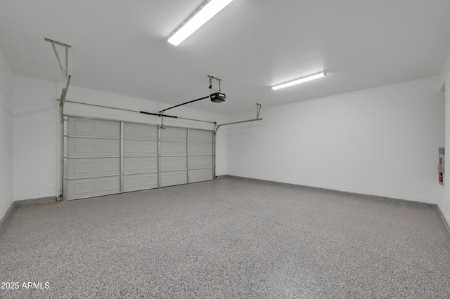 garage with a garage door opener and baseboards