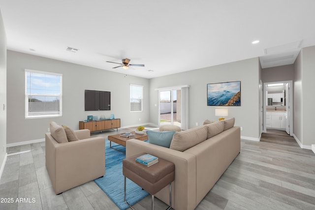 living room featuring visible vents, ceiling fan, light wood-type flooring, and baseboards