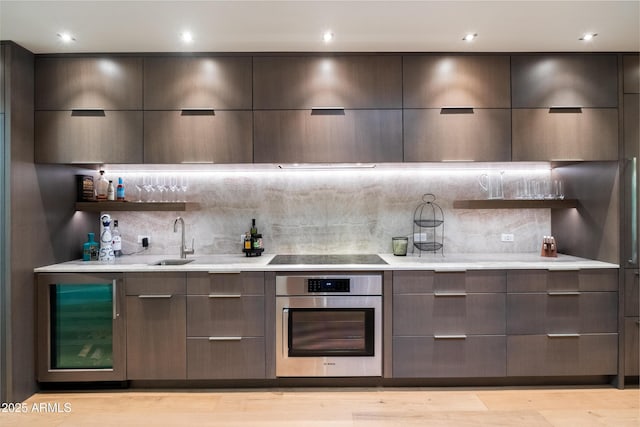 bar with wine cooler, sink, tasteful backsplash, stainless steel oven, and black electric stovetop