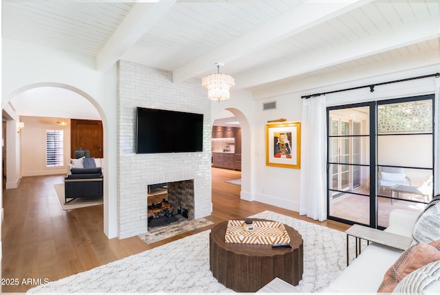 living room with hardwood / wood-style flooring, a fireplace, and beam ceiling