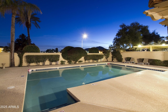 view of pool at dusk