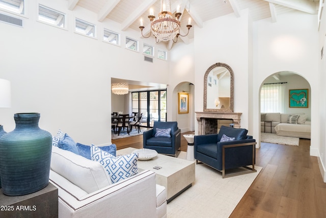 living room with an inviting chandelier, wood ceiling, wood-type flooring, and beam ceiling