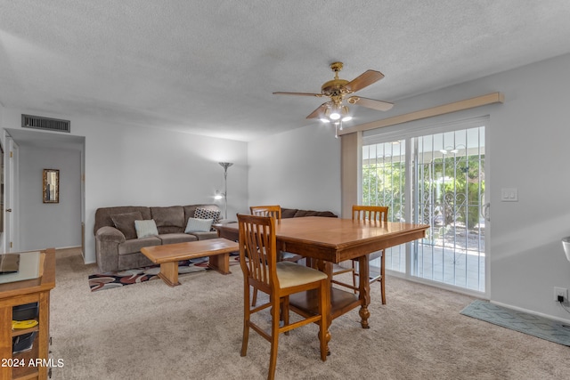 carpeted dining space featuring ceiling fan and a textured ceiling