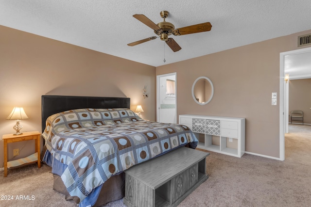 carpeted bedroom with ceiling fan and a textured ceiling