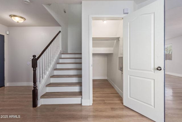 stairway with wood finished floors and baseboards