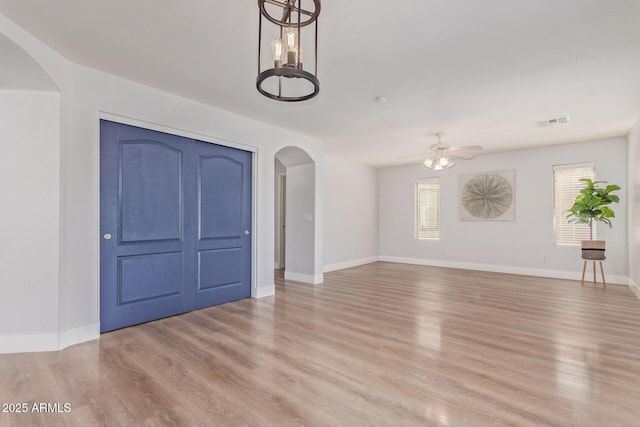 interior space with arched walkways, plenty of natural light, visible vents, and ceiling fan with notable chandelier