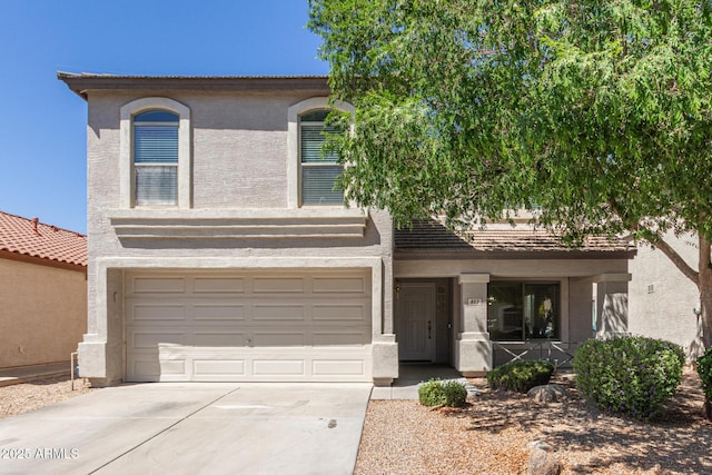 view of front of property with stucco siding, an attached garage, covered porch, and concrete driveway