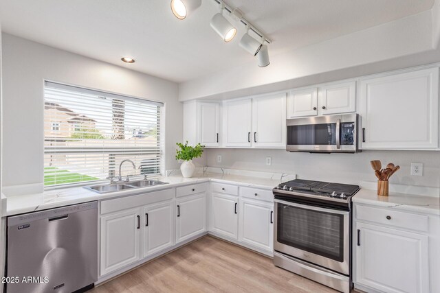kitchen with white cabinets, stainless steel appliances, and a sink