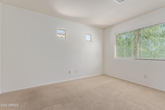 spare room with light colored carpet and baseboards