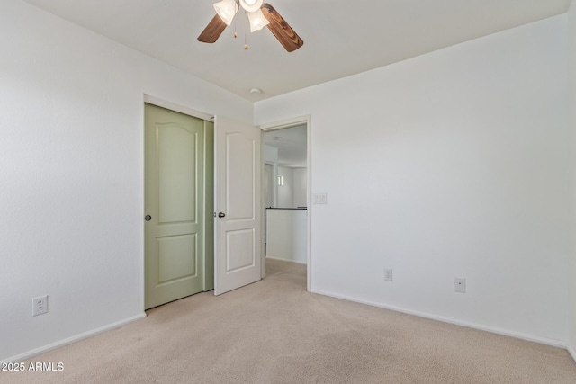 unfurnished bedroom with baseboards, a closet, a ceiling fan, and light colored carpet