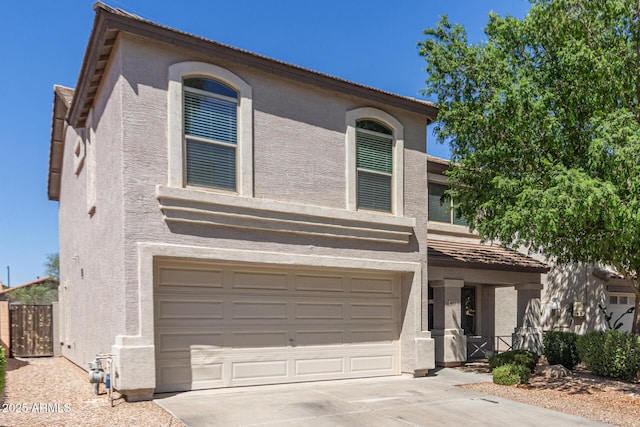 traditional home with stucco siding, concrete driveway, and a garage