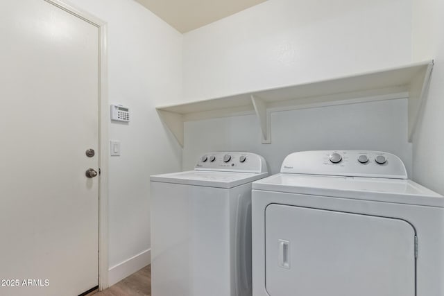 laundry room featuring washing machine and dryer, baseboards, laundry area, and light wood-type flooring