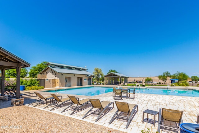 community pool featuring a gazebo, a patio area, and fence