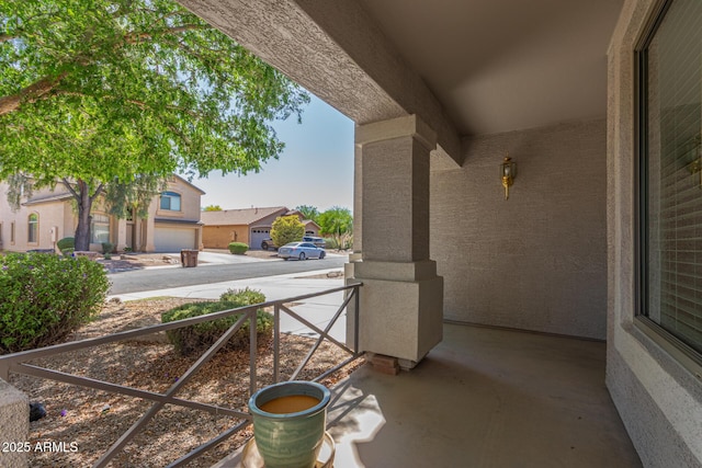 view of patio featuring driveway, covered porch, and a residential view