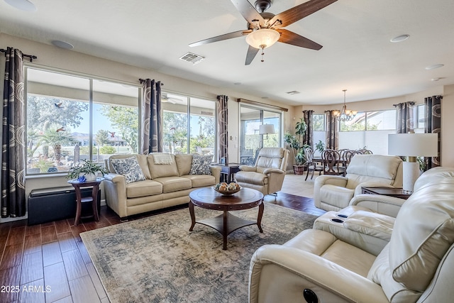 living room featuring ceiling fan with notable chandelier