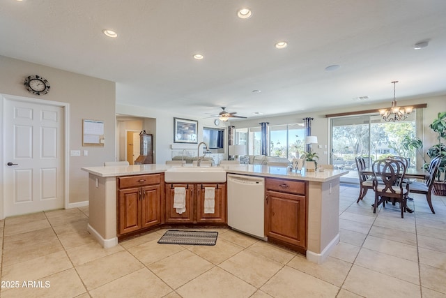 kitchen with decorative light fixtures, sink, dishwasher, and an island with sink