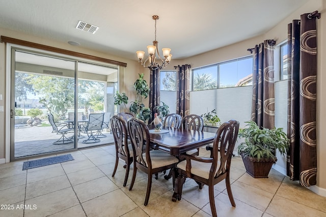 dining space featuring light tile patterned floors, a notable chandelier, and plenty of natural light