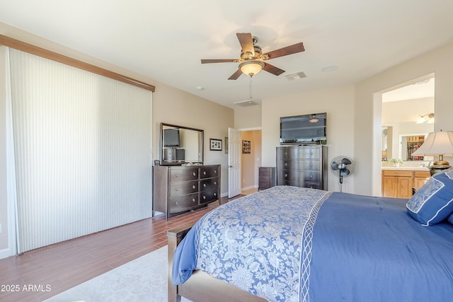 bedroom featuring ceiling fan, light wood-type flooring, and ensuite bathroom