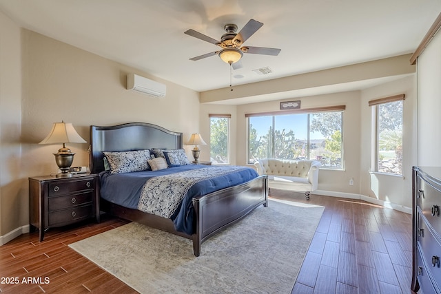 bedroom with a wall unit AC and ceiling fan