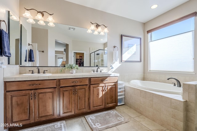 bathroom with vanity, tile patterned floors, and plus walk in shower