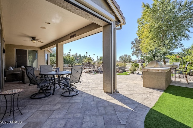 view of patio / terrace featuring ceiling fan and an outdoor kitchen