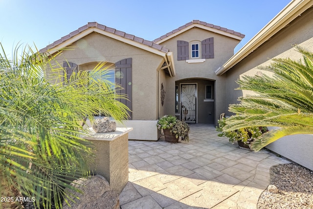 view of exterior entry featuring a patio