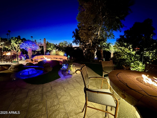 patio at twilight featuring an outdoor fire pit