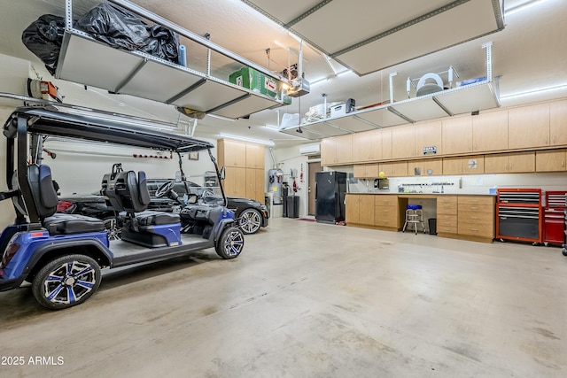 garage featuring black refrigerator and a garage door opener