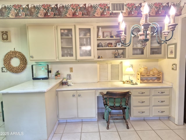 1118 E Orangewood Ave, Phoenix, AZ 85020 - home office with built in desk, light tile patterned floors, and a chandelier