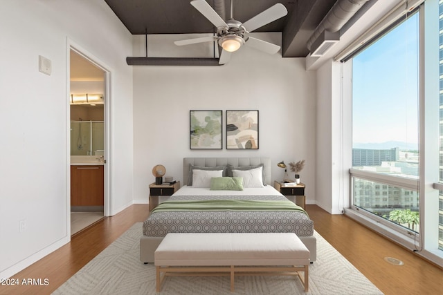 bedroom featuring hardwood / wood-style floors, ceiling fan, and ensuite bathroom