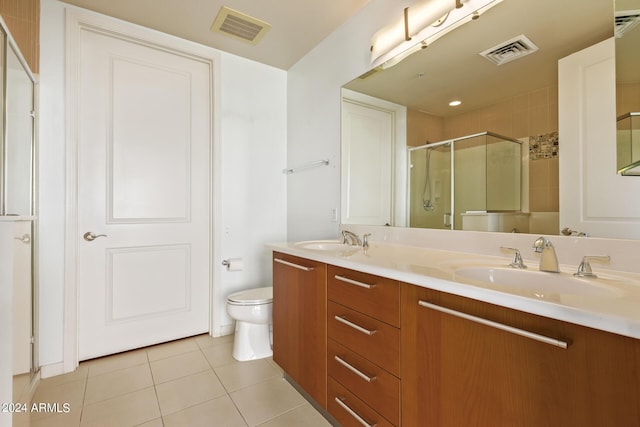 bathroom with an enclosed shower, vanity, tile patterned flooring, and toilet