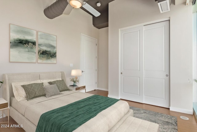 bedroom with hardwood / wood-style floors, a closet, and ceiling fan